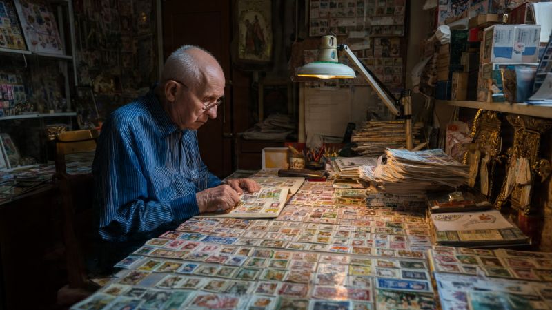 a man collecting stamps at his desk